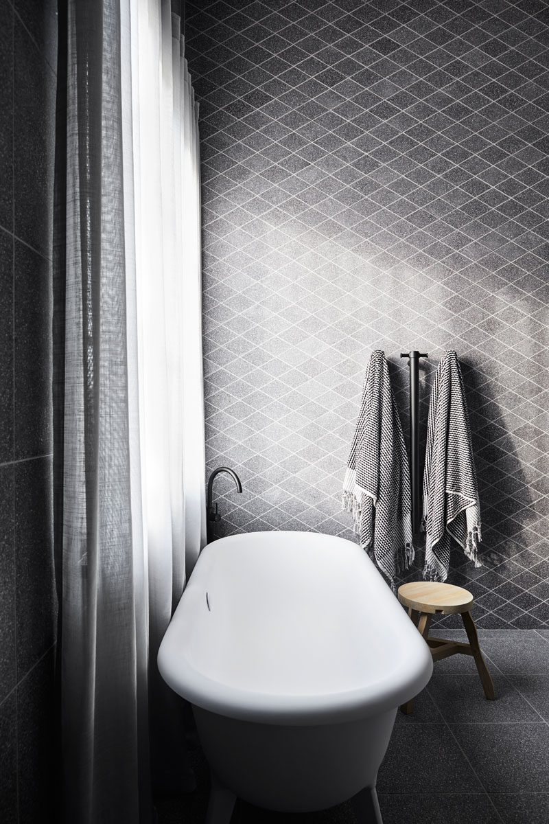 Идеи для ванных комнат - в этой современной главной спальне есть отдельная стена из алмазной плитки терраццо, вырезанная на заказ, которая обеспечивает фон для ванны Agape.
