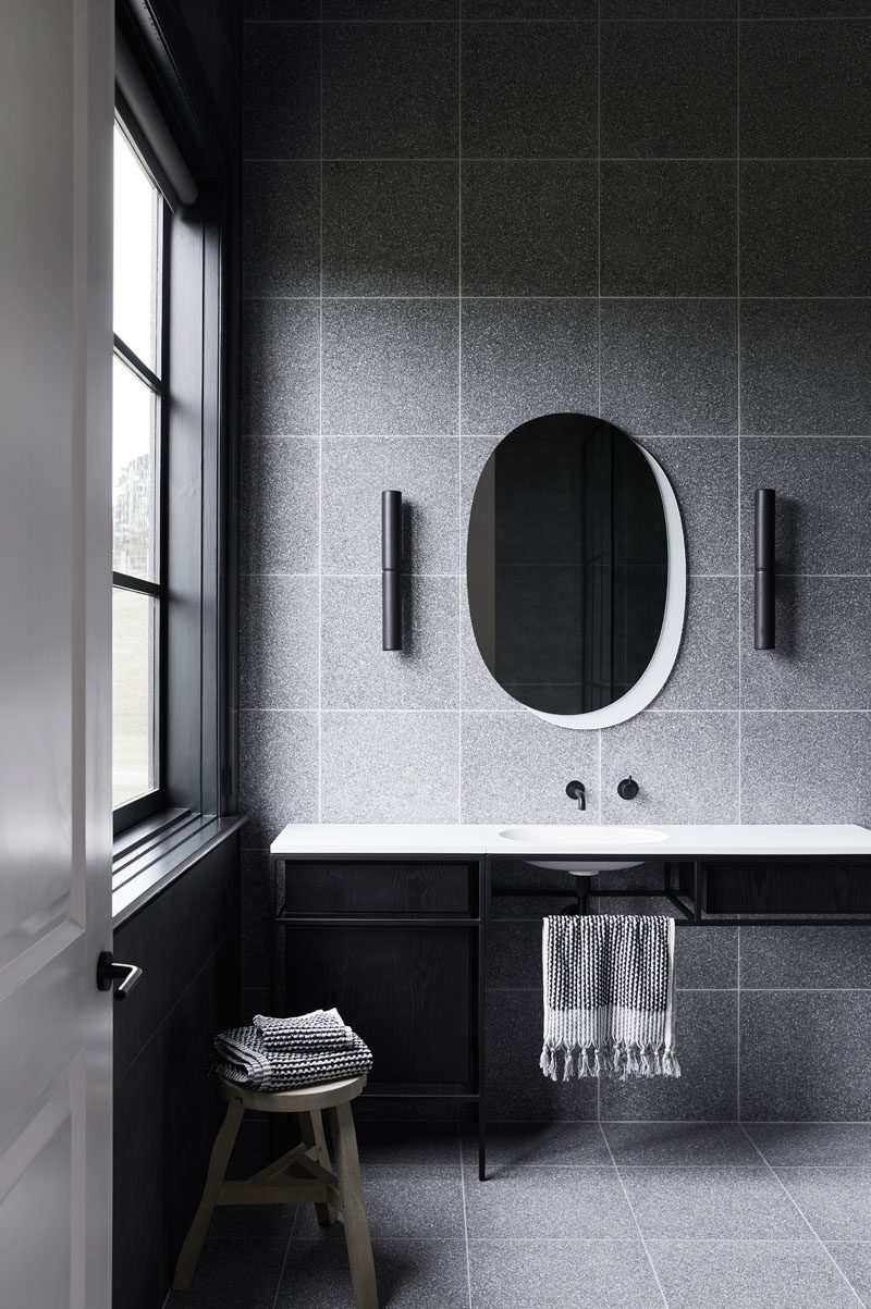 Идеи для ванных комнат - в этой современной серо-черно-белой ванной комнате серая плитка сочетается с туалетным столиком в черной рамке и белой столешницей со встроенной раковиной. # Идеи для ванной # Дизайн для ванной # Современная
