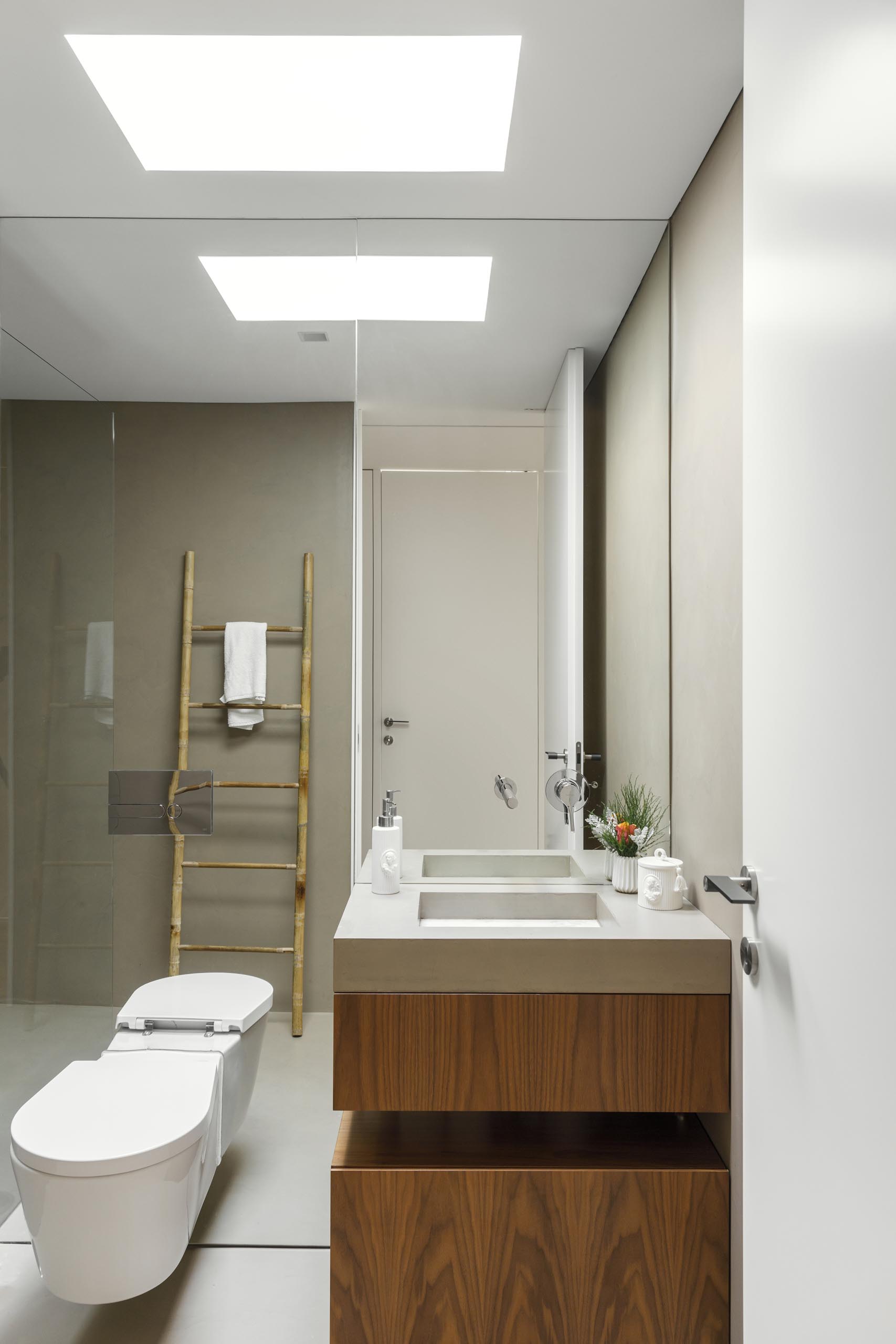 Современная ванная комната со встроенной раковиной и зеркалом от пола до потолка.