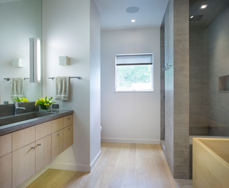 В этой современной ванной комнаты используются простые материалы, а под плавающим туалетным столиком скрыта подсветка. #BathroomDesign 