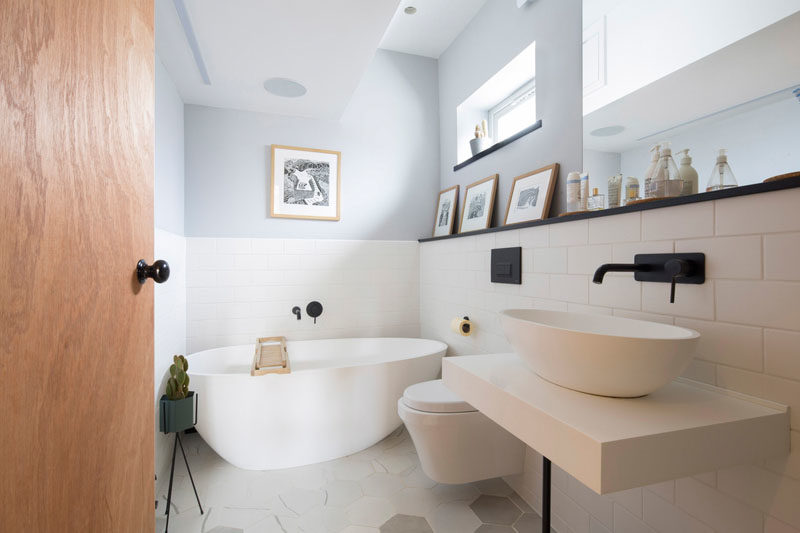 Идеи для ванных комнат - в этой современной ванной комнате нижняя половина комнаты оставлена ​​белой, а перила для картин служит местом для демонстрации произведений искусства, а также служит небольшим пространством для хранения предметов над туалетным столиком. #BathroomIdeas # ModernBathroom #BathroomDesign