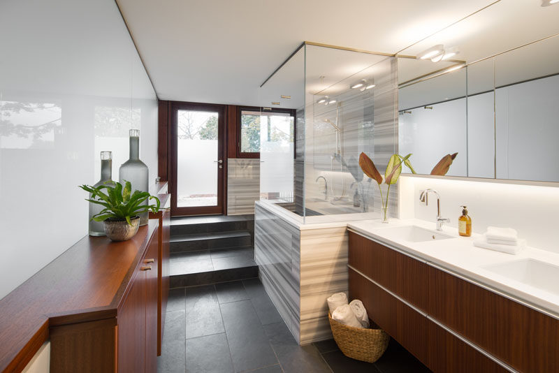 В этой современной ванной комнате деревянная мебель естественности, частично матовая дверь обеспечивает выход на улицу. # ВаннаяДизайн # Современный