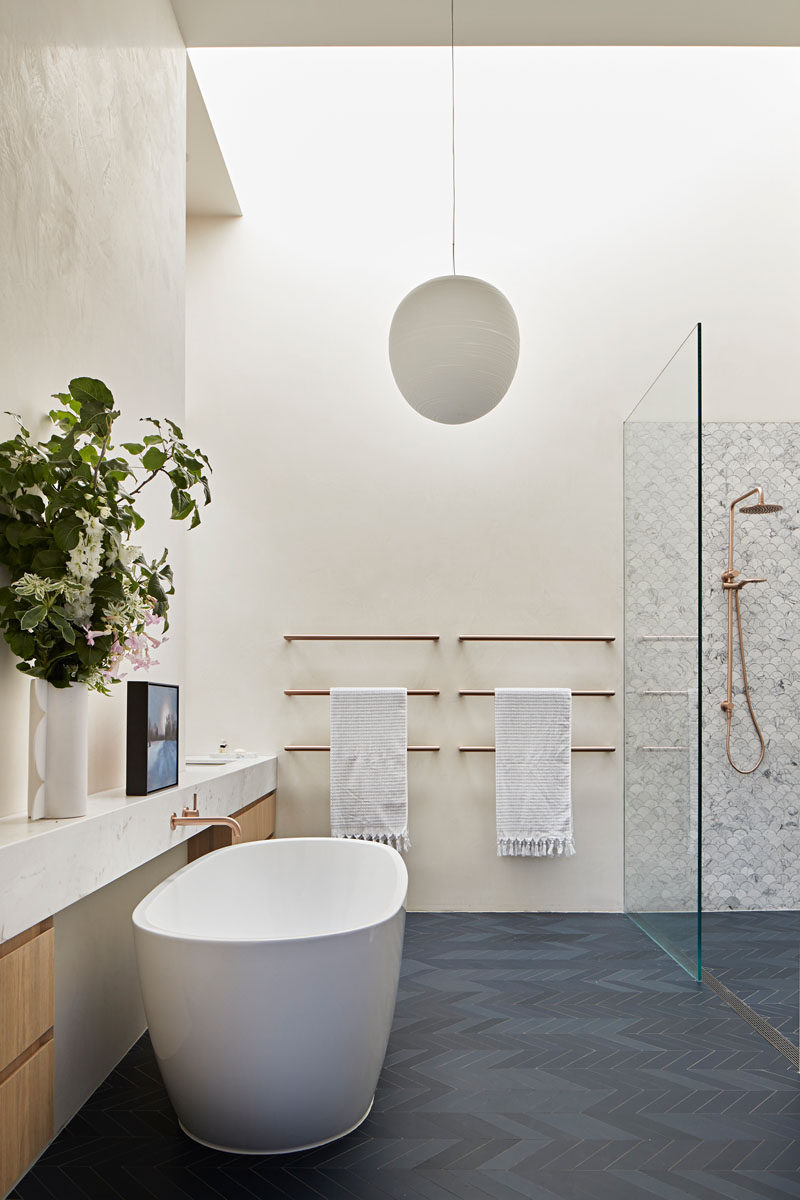  В этой современной ванной комнате темно-серый пол с узором в виде шеврона контрастирует с белыми стенами, а отдельно стоящая ванна находится напротив душа. # Современная ванная # Дизайн ванной 