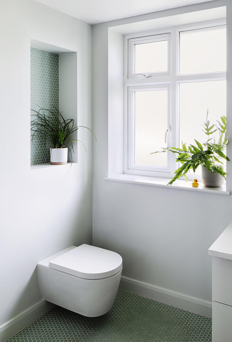 Эта современная ванная комната оснащена утопленной полкой, достаточно большой, чтобы можно было увидеть растение, и включает в себя небольшую шестиугольную плитку-пенни с белым раствором. Это также помогает добавить яркости простой серой стене и отвлекает внимание от унитаза внизу. # Полка для ванной # Идеи для ванной # Полка для ванной # ПенниПлитка # Дизайн для ванной
