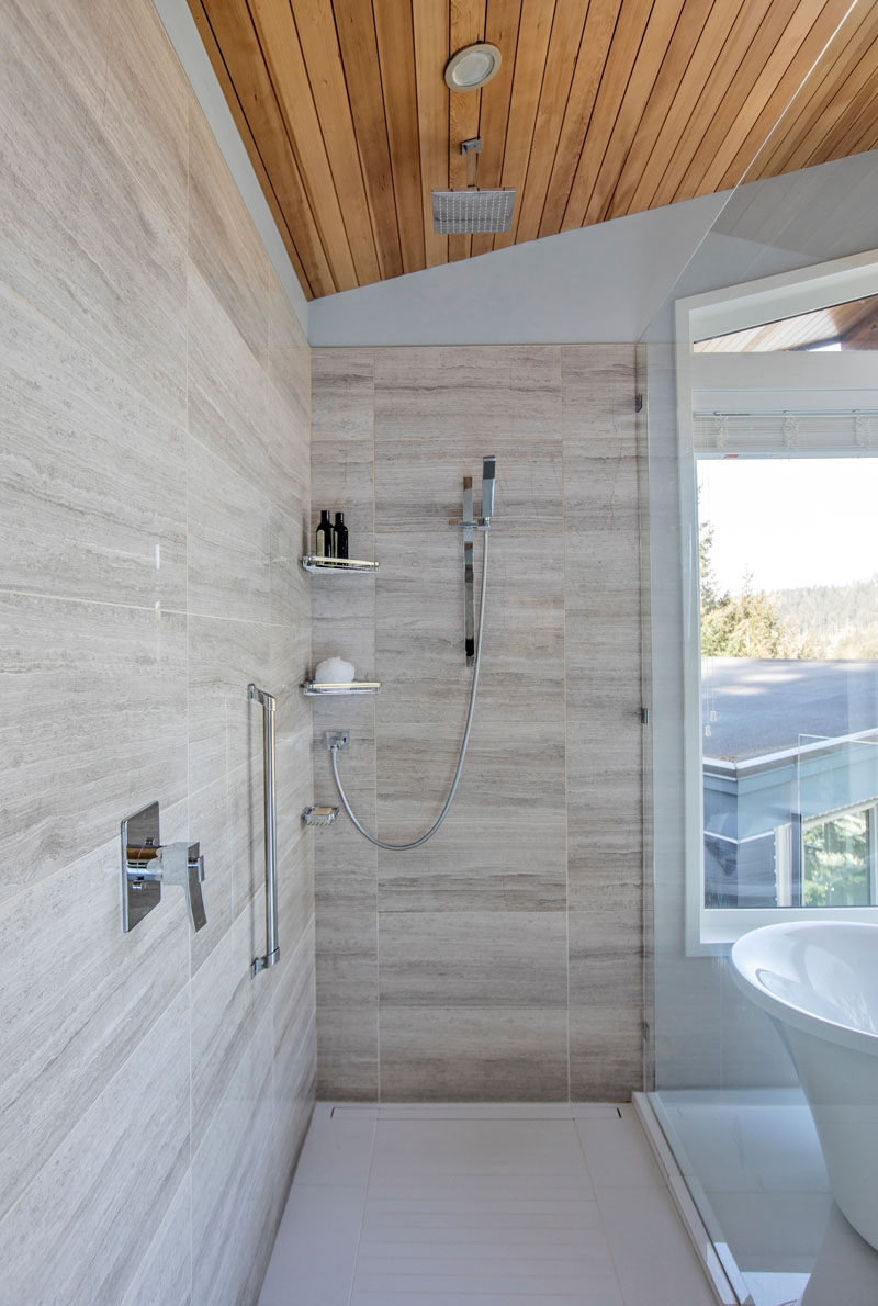  Стеклянная перегородка для душа отделяет душ от зоны ванны в этой современной ванной комнате, а в душе есть как тропический душ, так и настенный. # Душ # МодернДуш 