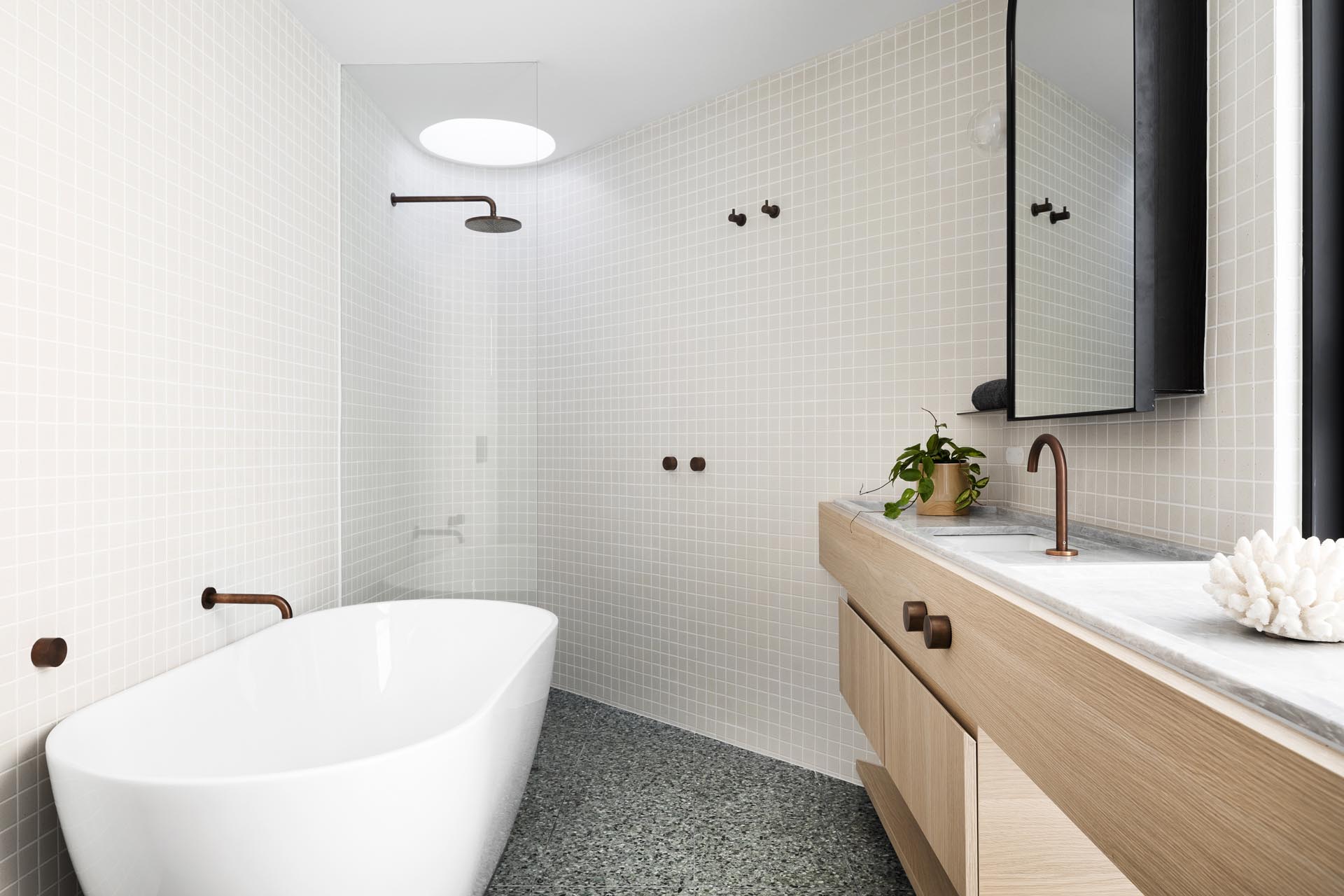 Современная ванная комната с деревянной раковиной и изогнутой стенкой с душем.