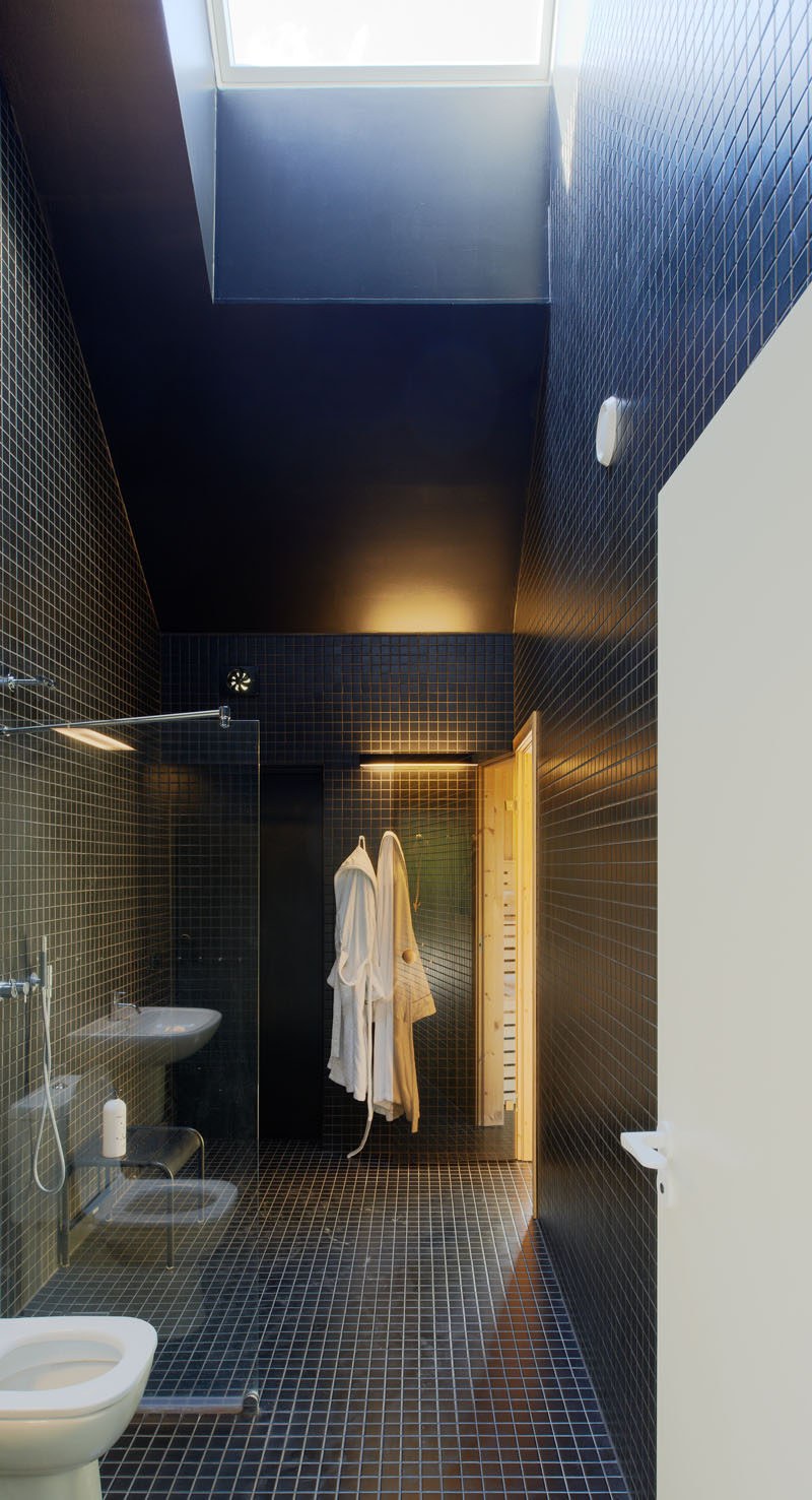 Идея плитки для ванной - используйте одну и ту же плитку на полу и стенах | Небольшая квадратная темно-синяя плитка покрывает пол и стены ванной комнаты в этом семейном доме.
