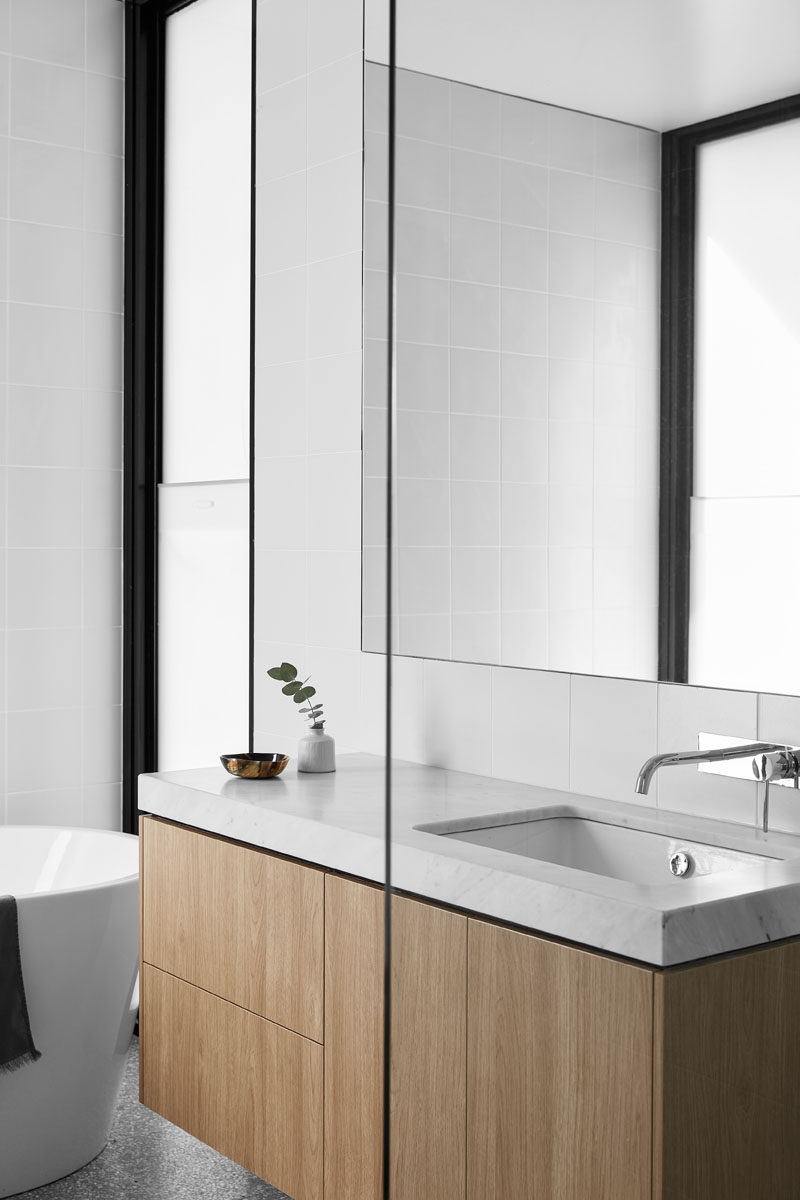 В этой современной ванной комнате деревянный туалетный столик верх естественности белому пространству. # Современная # Древесина