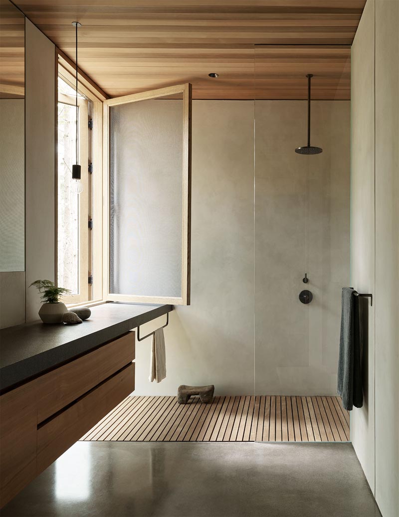 В этой современной ванной комнате есть большое окно, обеспечивающее естественное освещение для душа, а парящий туалетный столик с деревянной мебелью дополняет деревянный потолок. # ВаннаяДизайн # Современный