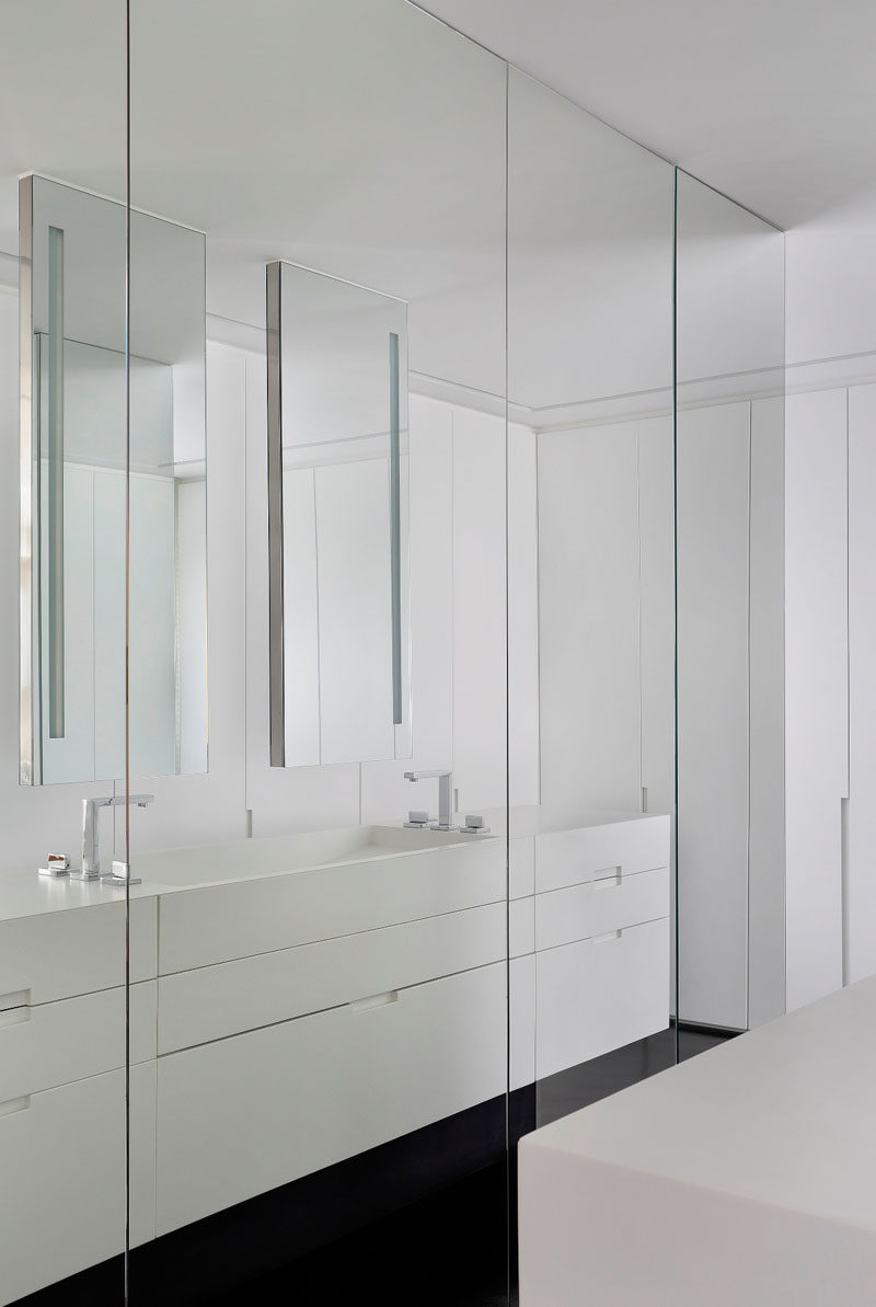 Полноценные зеркала от пола до потолка покрывают эти шкафы в этой современной ванной комнате и позволяют вам со всех сторон рассмотреть свой наряд перед тем, как выйти.
