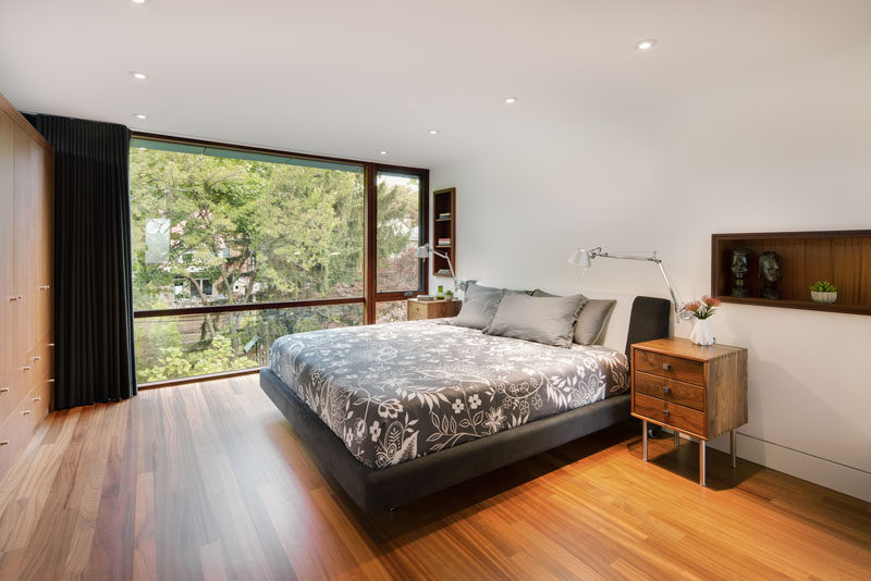 В этой современной спальне в стену встроены обшитые деревом стеллажи, а напротив кровати - стена, полный шкафов. # Спальня # Стеллажи 