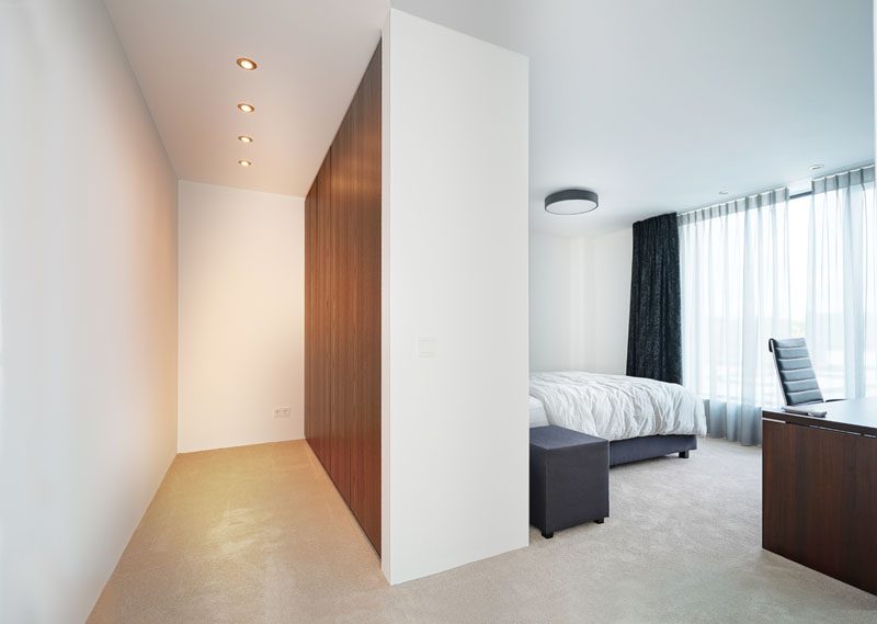 В этой спальне есть окна от пола до потолка и частичная стена, которая служит фоном для кровати и служит шкафом с другой стороны. # СпальняДизайн # СовременнаяСпальня