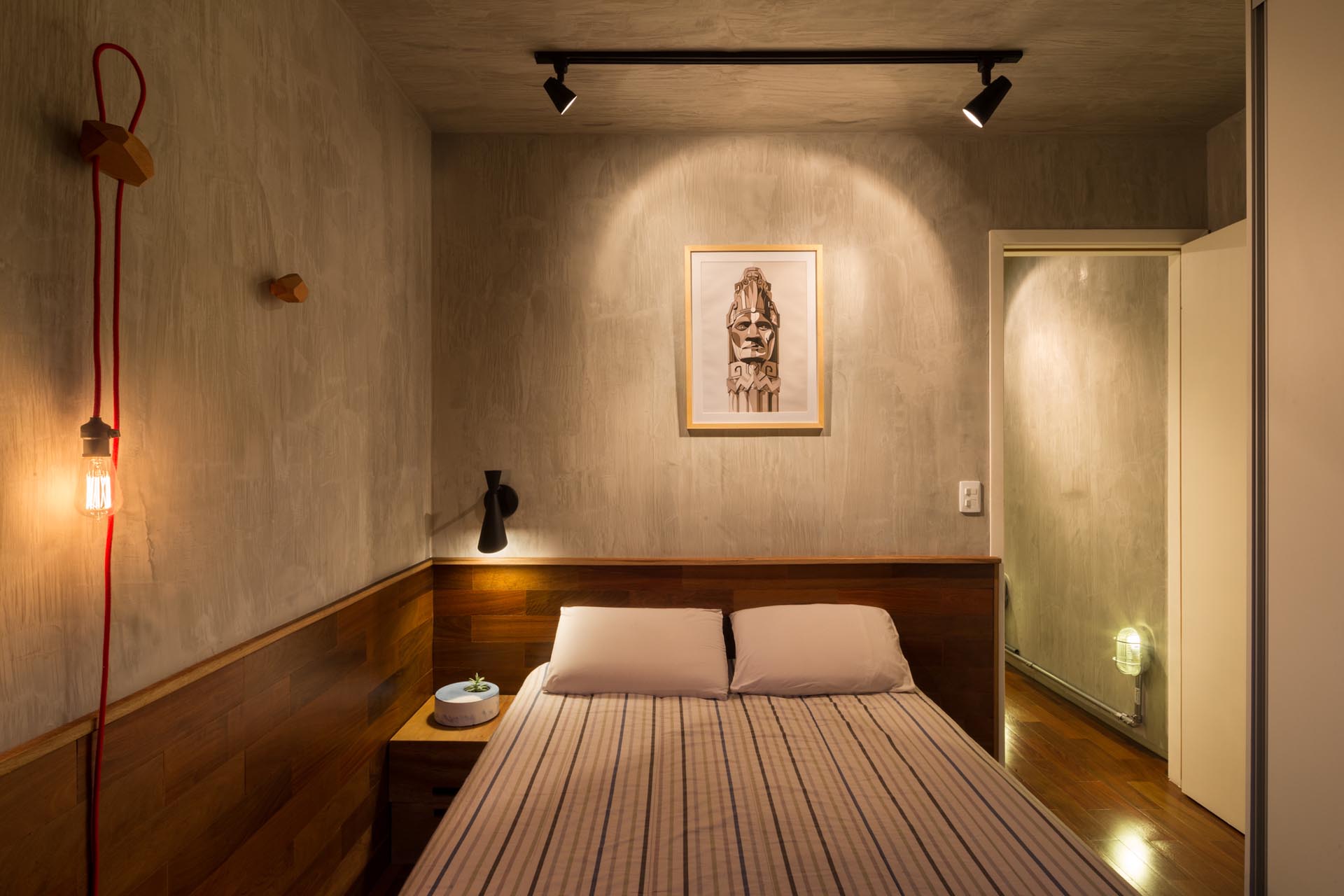 Современная спальня с деревянной акцентной стеной.