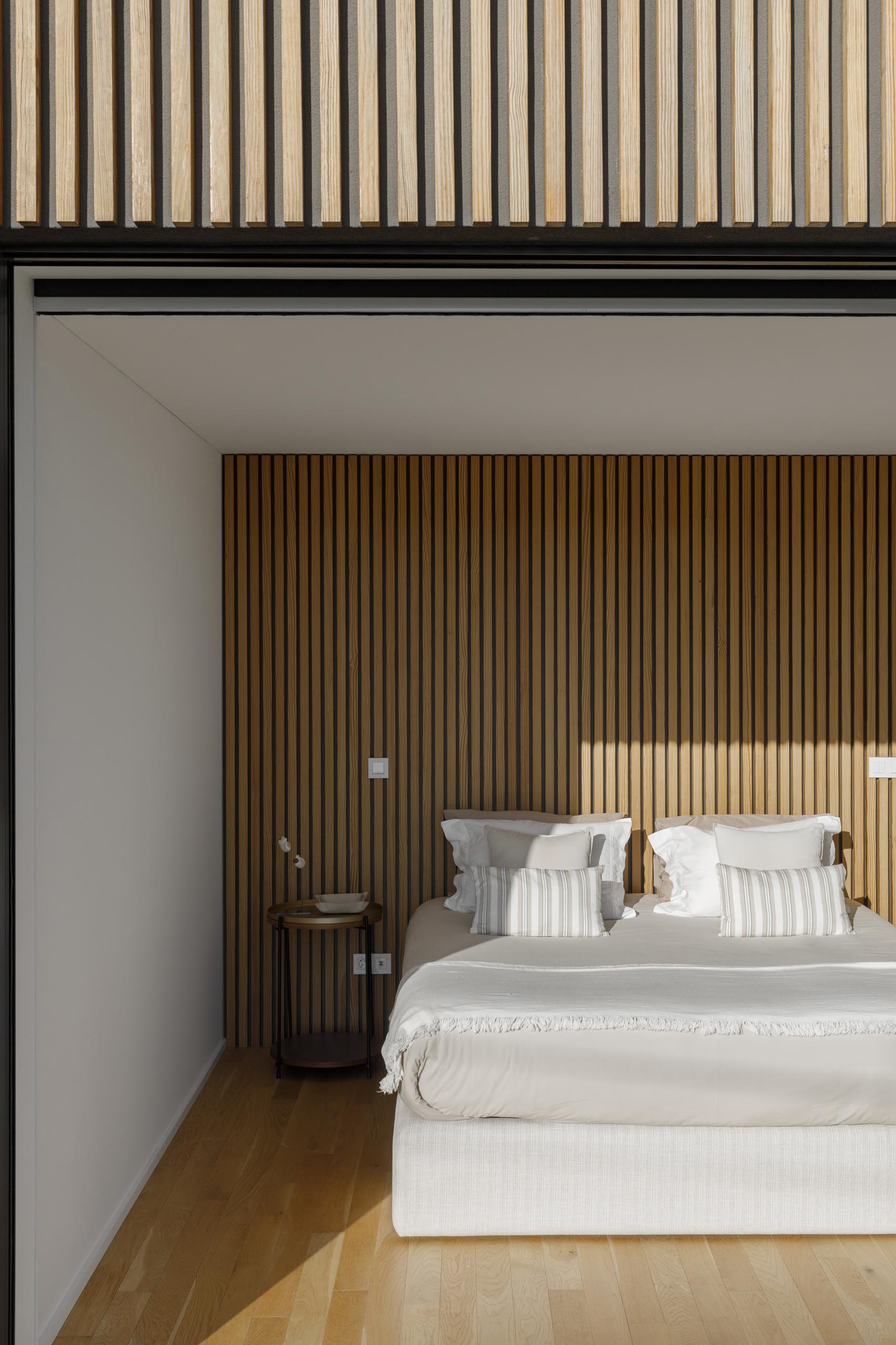 Современная спальня с акцентной стеной из деревянных реек.