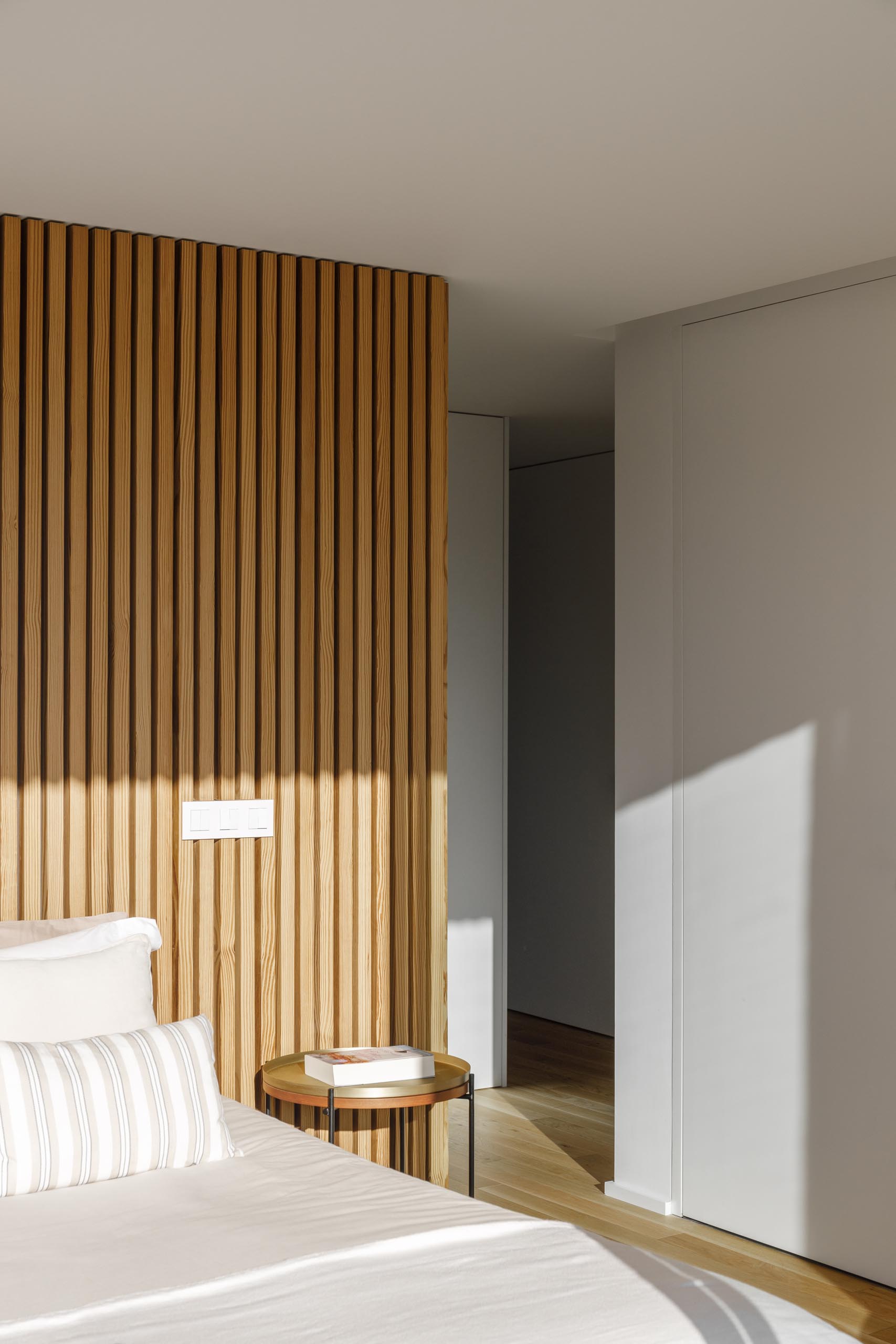 Современная спальня с акцентной стеной из деревянных реек.