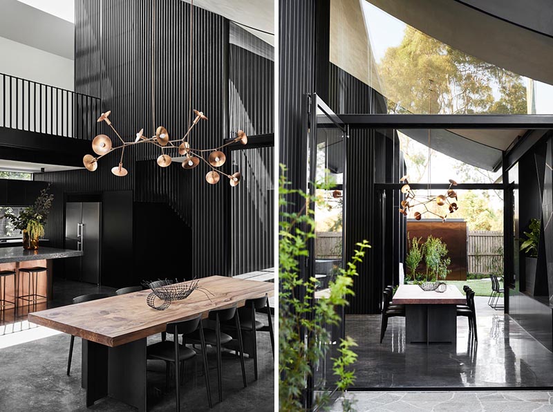 К кухне в этом современном доме примыкает обеденная зона с большим скульптурным светом, расположенным прямо над столом из дерева и черного металла. #DiningTable #DiningArea