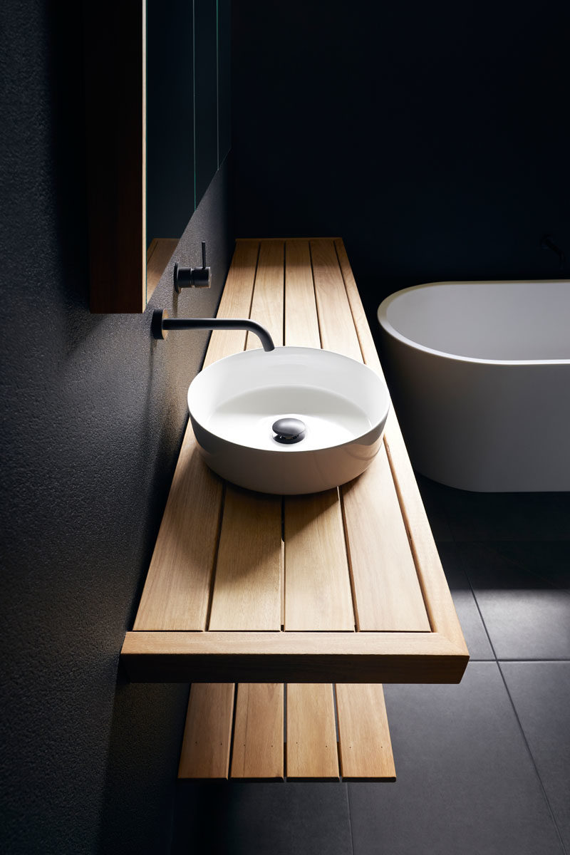 Современная ванная комната с матовыми черными стенами, деревянным туалетным столиком, белой раковиной и ванной. #BlackBathroom # ModernBathroom