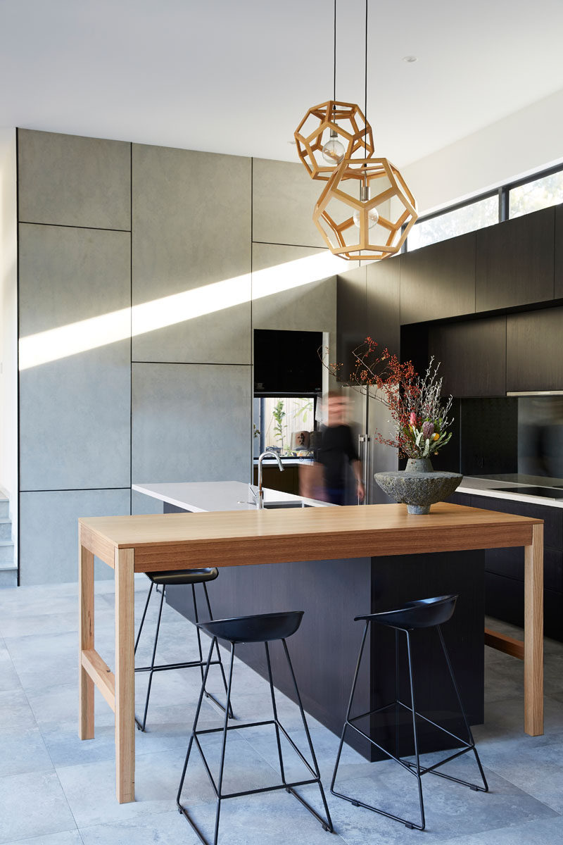  В этой современной кухне черные шкафы сочетаются с деревянными элементами и белыми столешницами. #ModernKitchen #KitchenDesign 