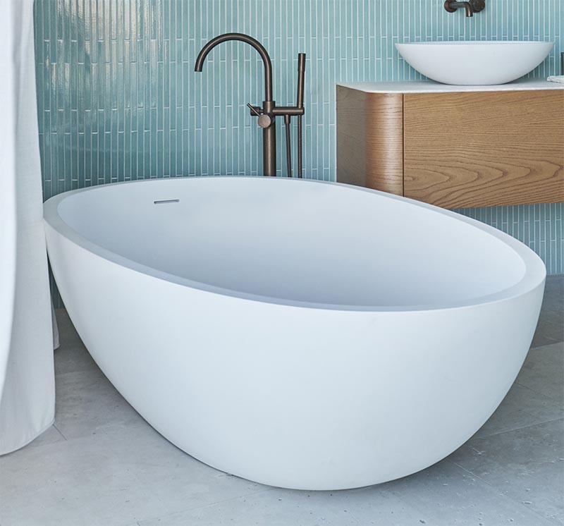 Отдельностоящая белая закругленная ванна дополняет умывальник, а бронзовый смеситель добавляет металлический оттенок. # СовременнаяВанная # БелаяВанна #Дизайн ванной