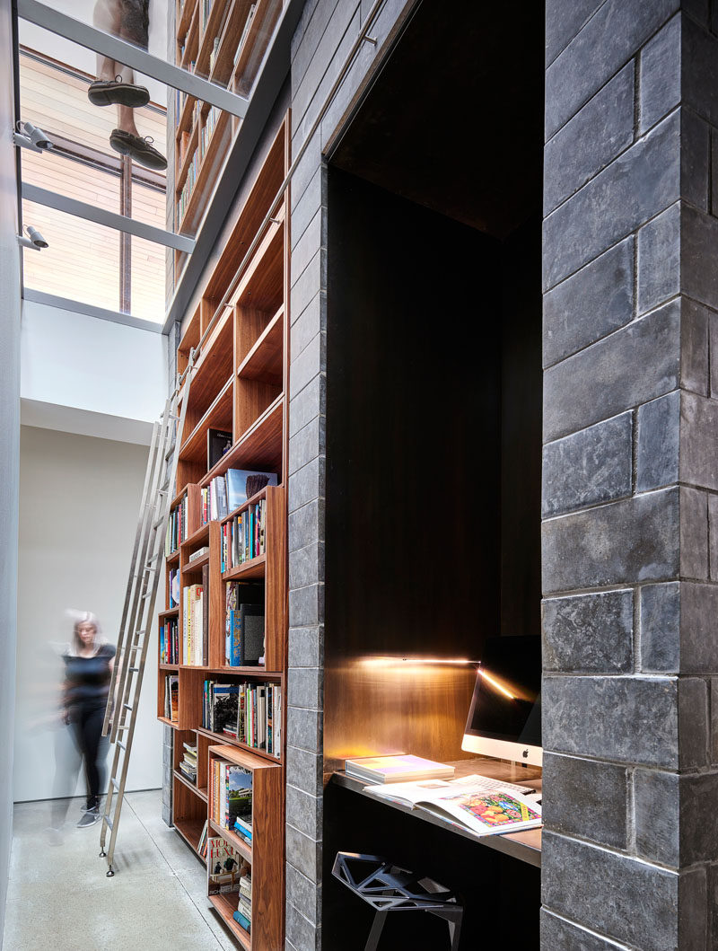В этом современном доме есть библиотека со встроенной деревянной книжной полкой и альков с письменным столом и компьютером. # Книжная полка #BuiltInBookshelf