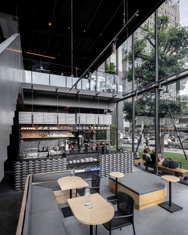 На первом этаже этой современной кофейни находится сервис-бар, где натуральный дуб с закругленными краями дополнен светло-серыми подушками и банкетками. #CoffeeShop #ModernCafe #CoffeeShopDesign #InteriorDesign