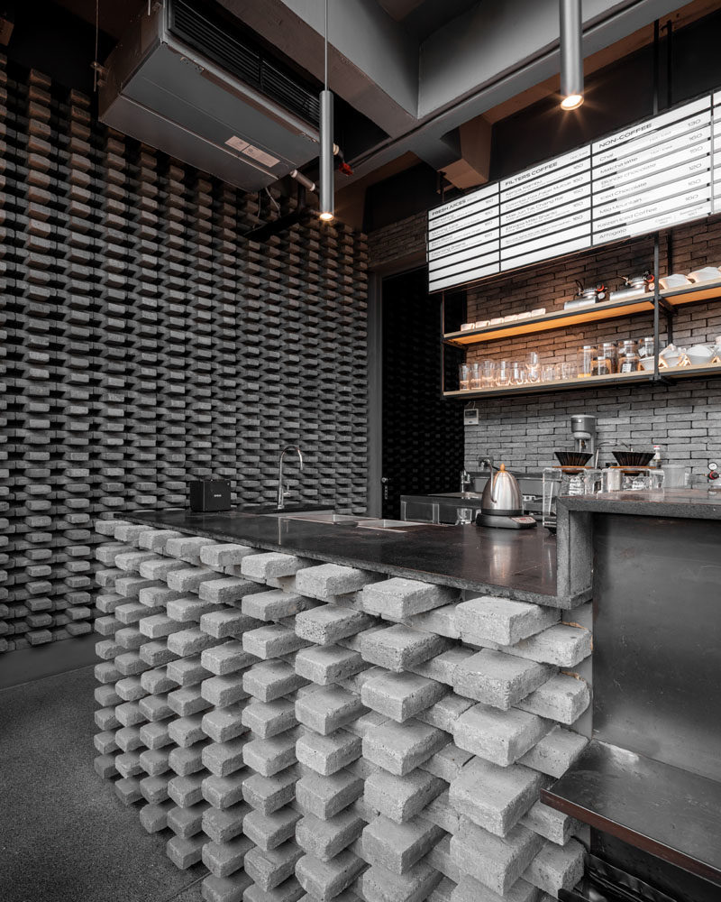 Эта современная кофейня имеет отчетливый узор из серого кирпича, который был установлен на барной стойке и на стене, добавляя уникальный элемент дизайна в пространство. #GreyBricks #CoffeeShop #GreyBrick #InteriorDesign