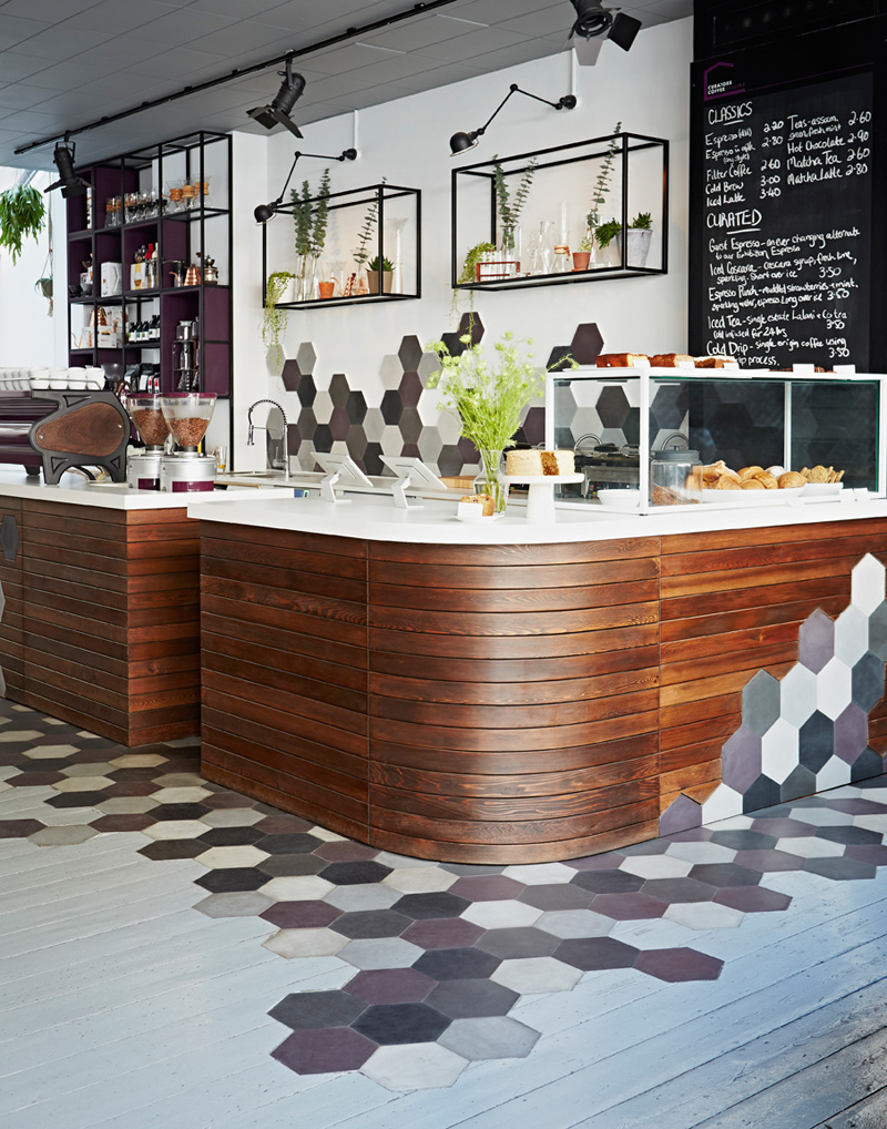 Эта кофейня в Лондоне использует шестиугольники, дерево и сложную, но игривую цветовую палитру, чтобы создать уютное кафе.