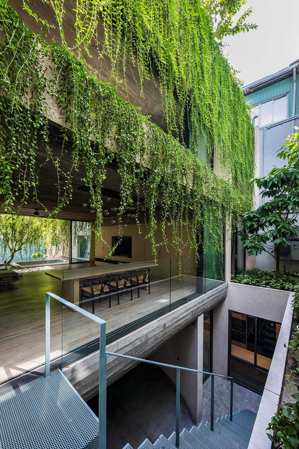 Современный многоэтажный дом с нависающими растениями.