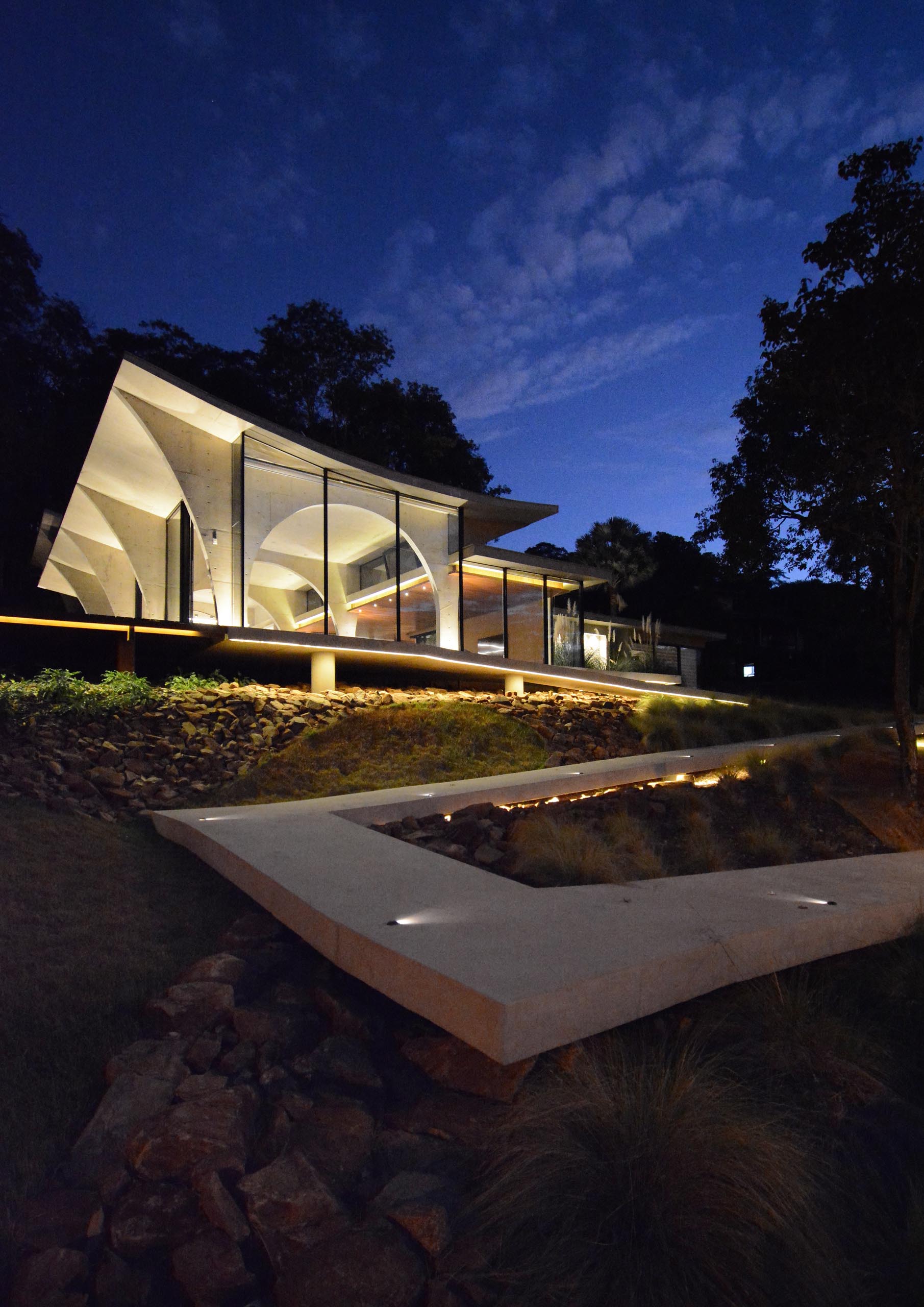 Этот современный бетонный дом имеет многочисленные арки, которые особенно хорошо видны ночью, так как внутренний свет подчеркивает изгибы.