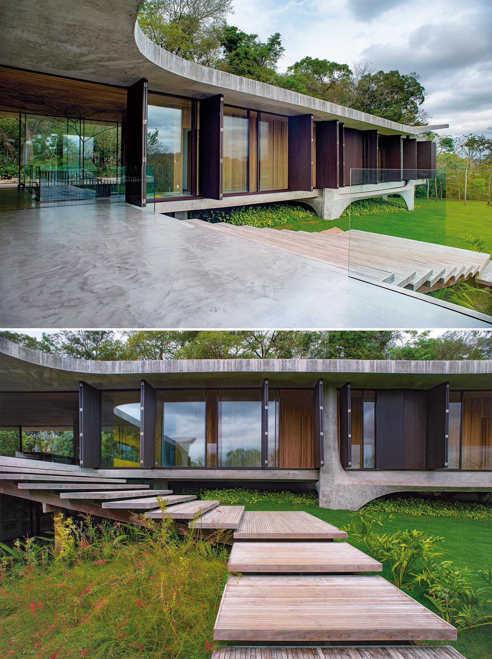Этот современный бетонный дом имеет деревянную лестницу, ведущую из основного жилого этажа во двор и к бассейну.