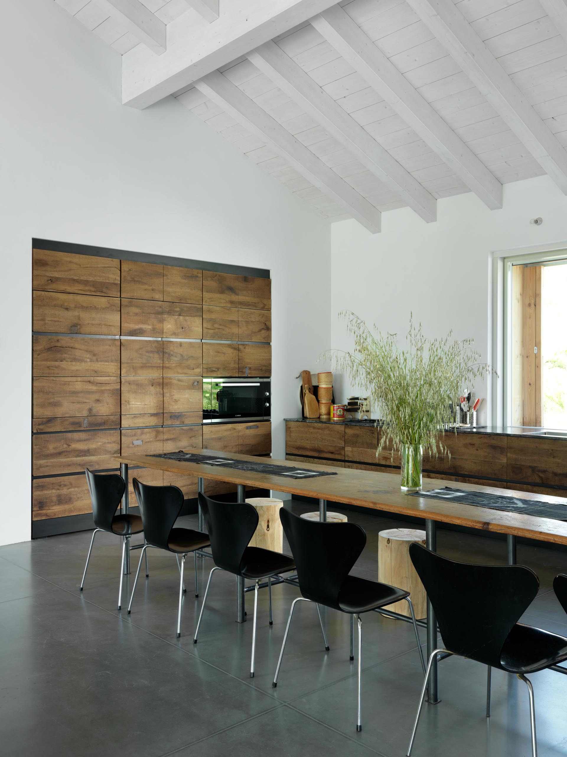 Кухня в этом современном доме сделана на заказ с использованием мелиорированной древесины, что добавляет эстетики фермерскому дому.