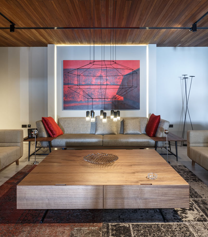 Эта формальная гостиная украшена люстрой в стиле минимализма с яркими красными произведениями искусства и подушками, которые добавляют яркости. # Гостиная # Жилая комната
