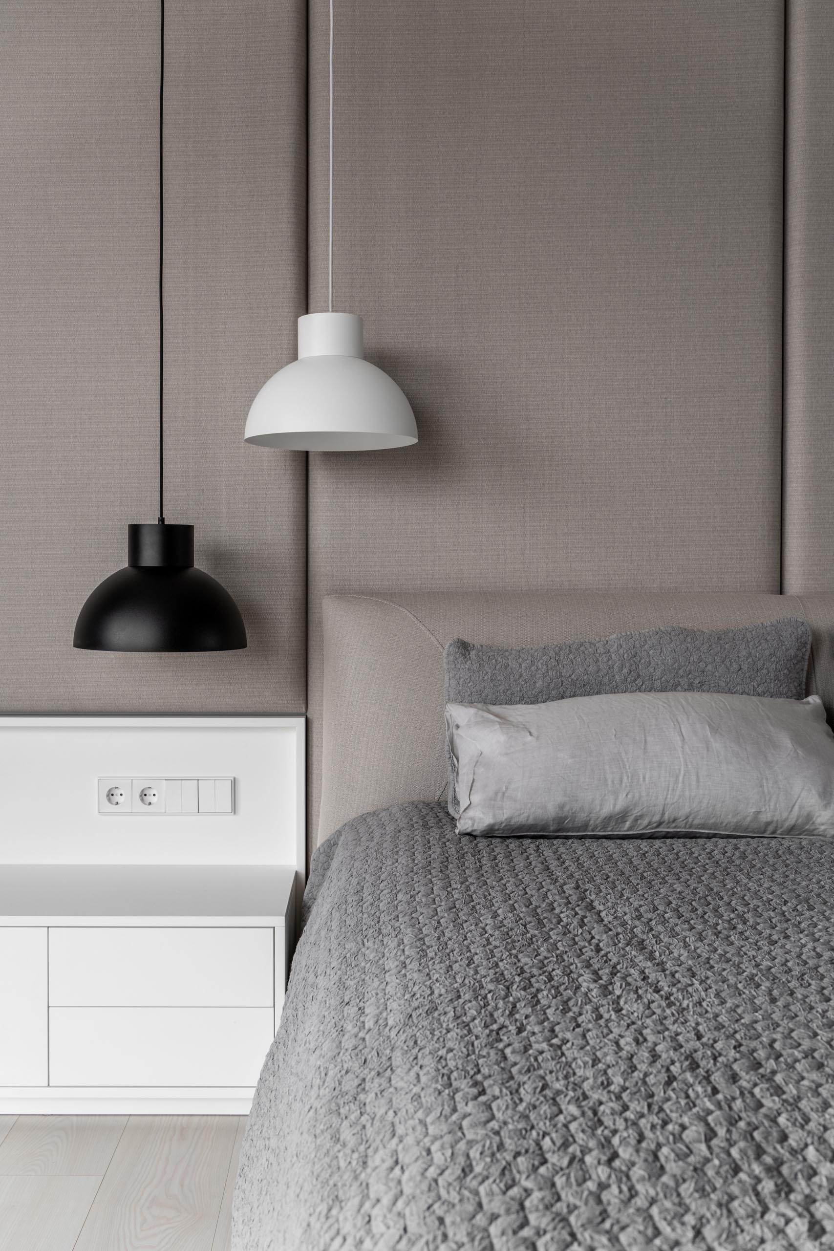 Современная спальня в серо-бежевой цветовой гамме с белыми и черными акцентами.