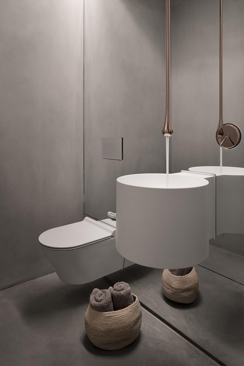В этой современной ванной комнате серые стены отражаются во всем настенном зеркале, а смеситель спускается прямо с потолка, создавая яркий и неожиданный элемент дизайна. # Дизайн ванной # Современная ванная # СерыйВанная