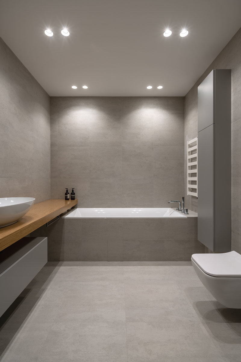 Идеи для ванных комнат - в этой современной ванной комнате серая плитка большого формата покрывает стены и пол, а деревянный туалетный столик добавляет естественности. # Современная ванная # Дизайн ванной # Идеи для ванной