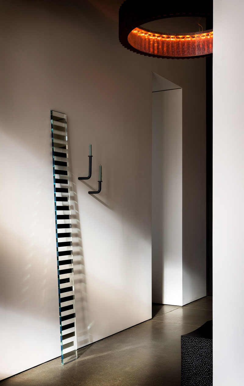 Идеи для прихожей. В этом современном коридоре представлены такие экспонаты, как культовая скамья Джона Эрика Байерса из почерневшего клена и художественное зеркало «Видящее стекло» Сабины Марселис. #HallwayIdeas #ModernHallway