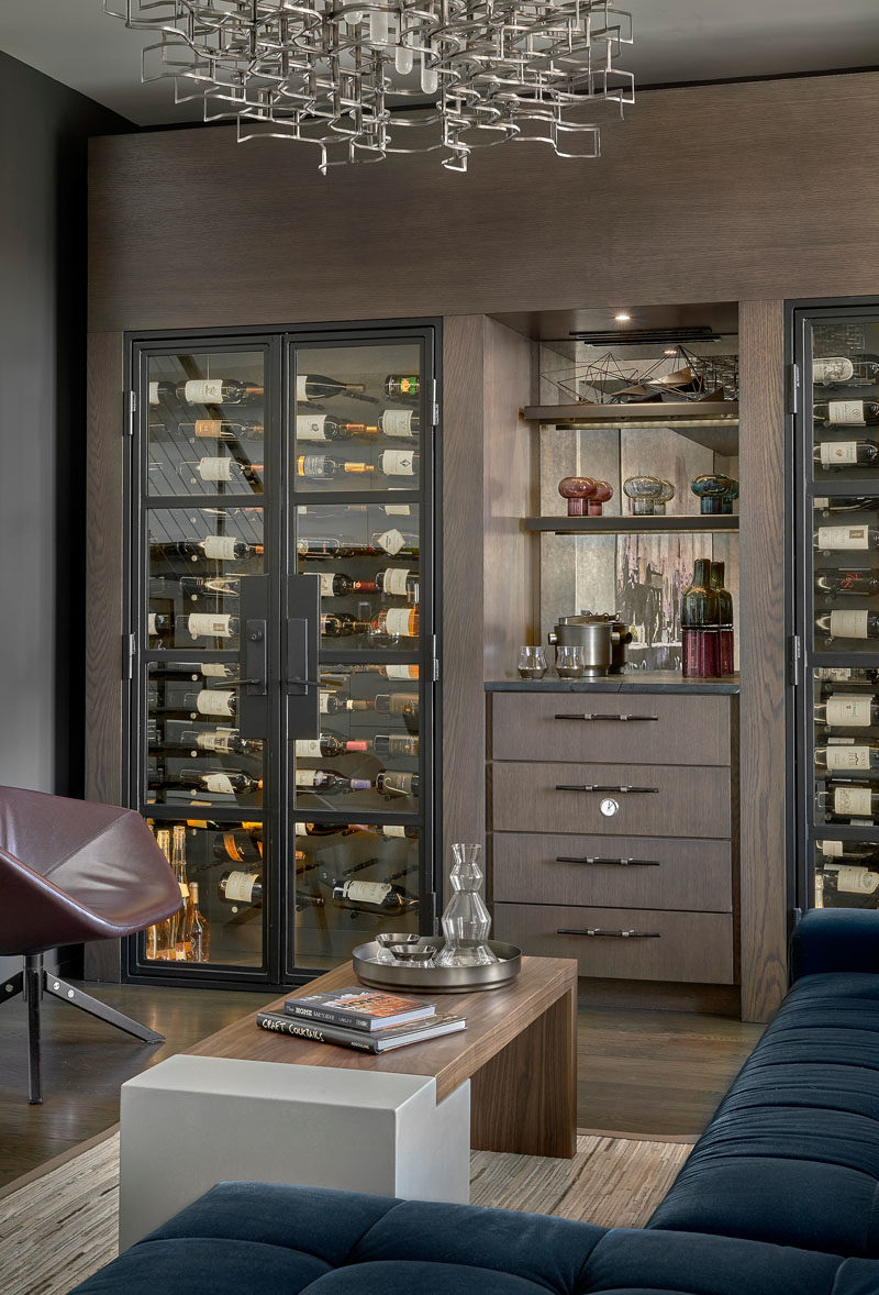 Идеи винной комнаты - эта современная винная комната была отделана чернильно-синей секцией, имеет изготовленные на заказ винные холодильники и люстру Люси Сливински, сделанную из металлических автомобильных деталей. #WineRoom #WineStorage #Lounge #HomeBar