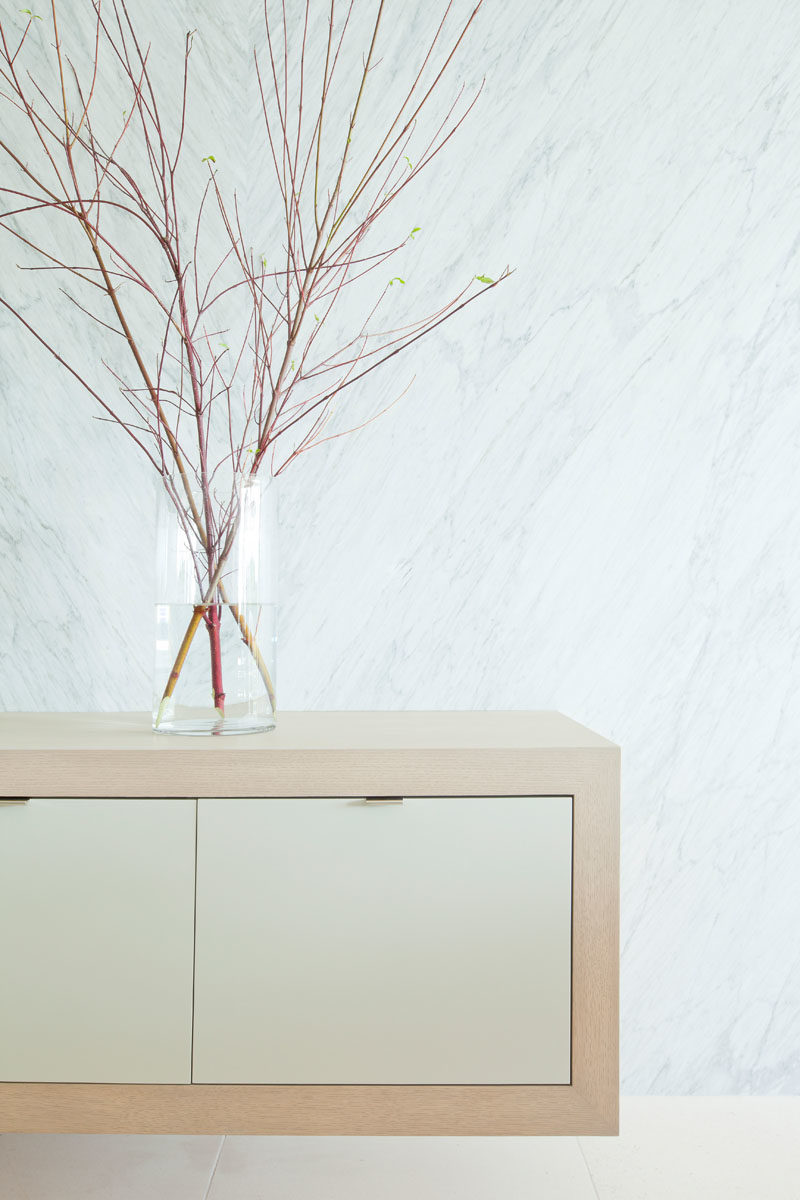 Идеи декора - простой парящий деревянный шкаф увенчан стеклянной вазой с коллекцией веточек. #ModernDecor #DecorIdeas