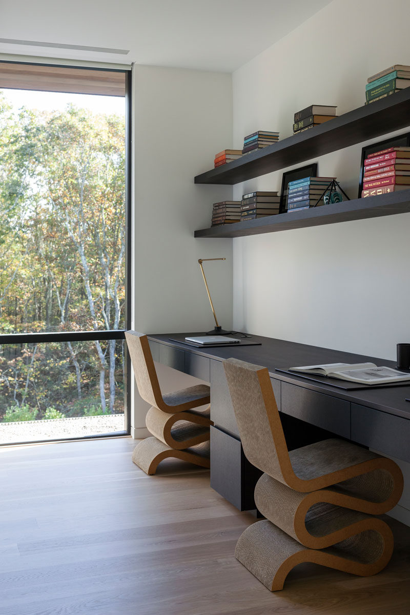 В этом В современном офисе есть встроенный стол, в котором достаточно места для двух человек, и стеллажи над ними, которые находятся в книжной полке. #HomeOffice #ModernHomeOffice 