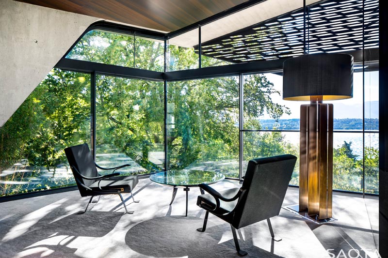 Этот современный домашний офис пользуется захватывающими видами, тенью от деревьев и перфорированной ширмой на внешней стороне дома. #ModernHomeOffice #GlassWalls