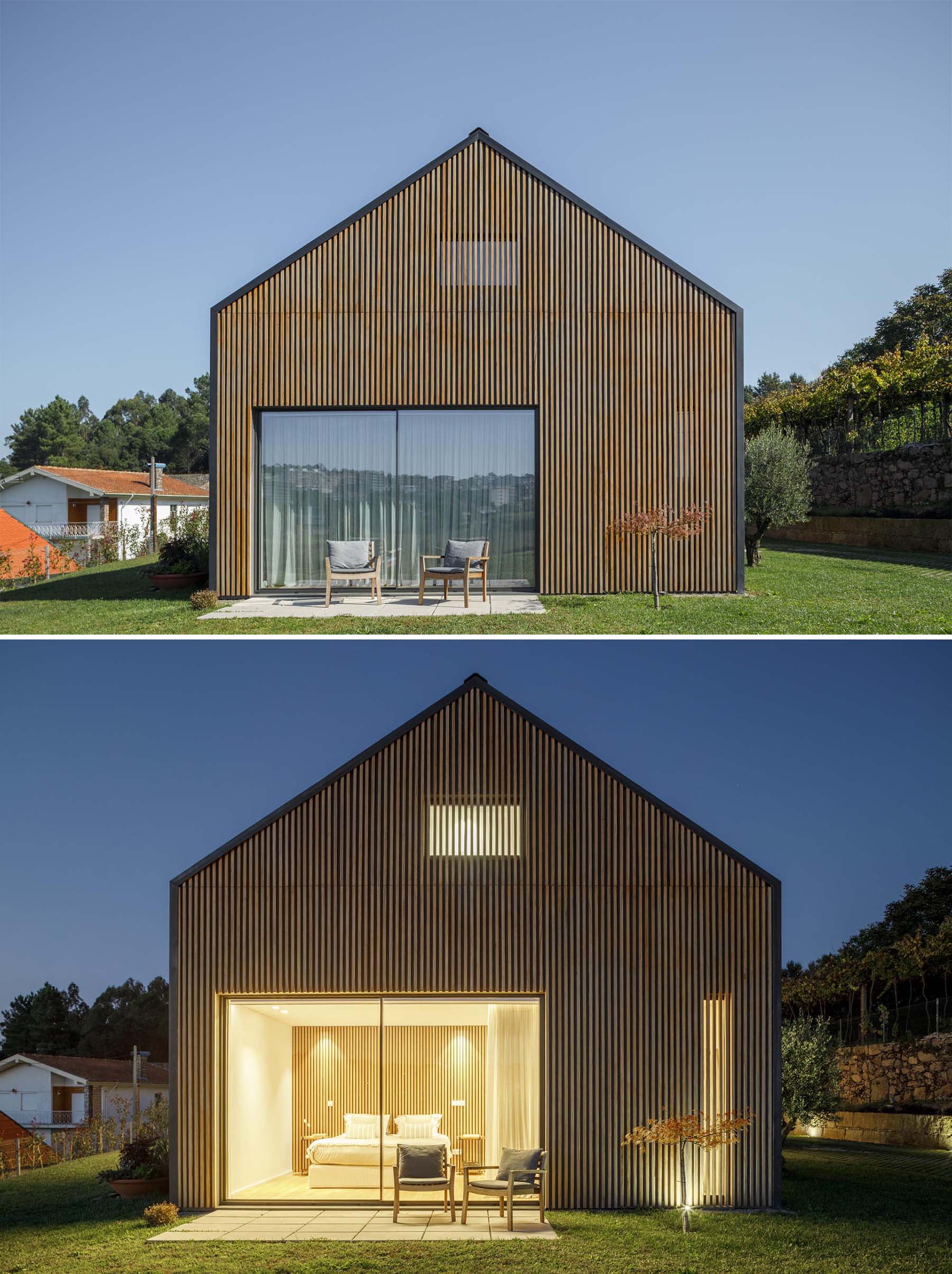 Современный дом со стеной из деревянных реек, которая несколько скрывает пару окон.