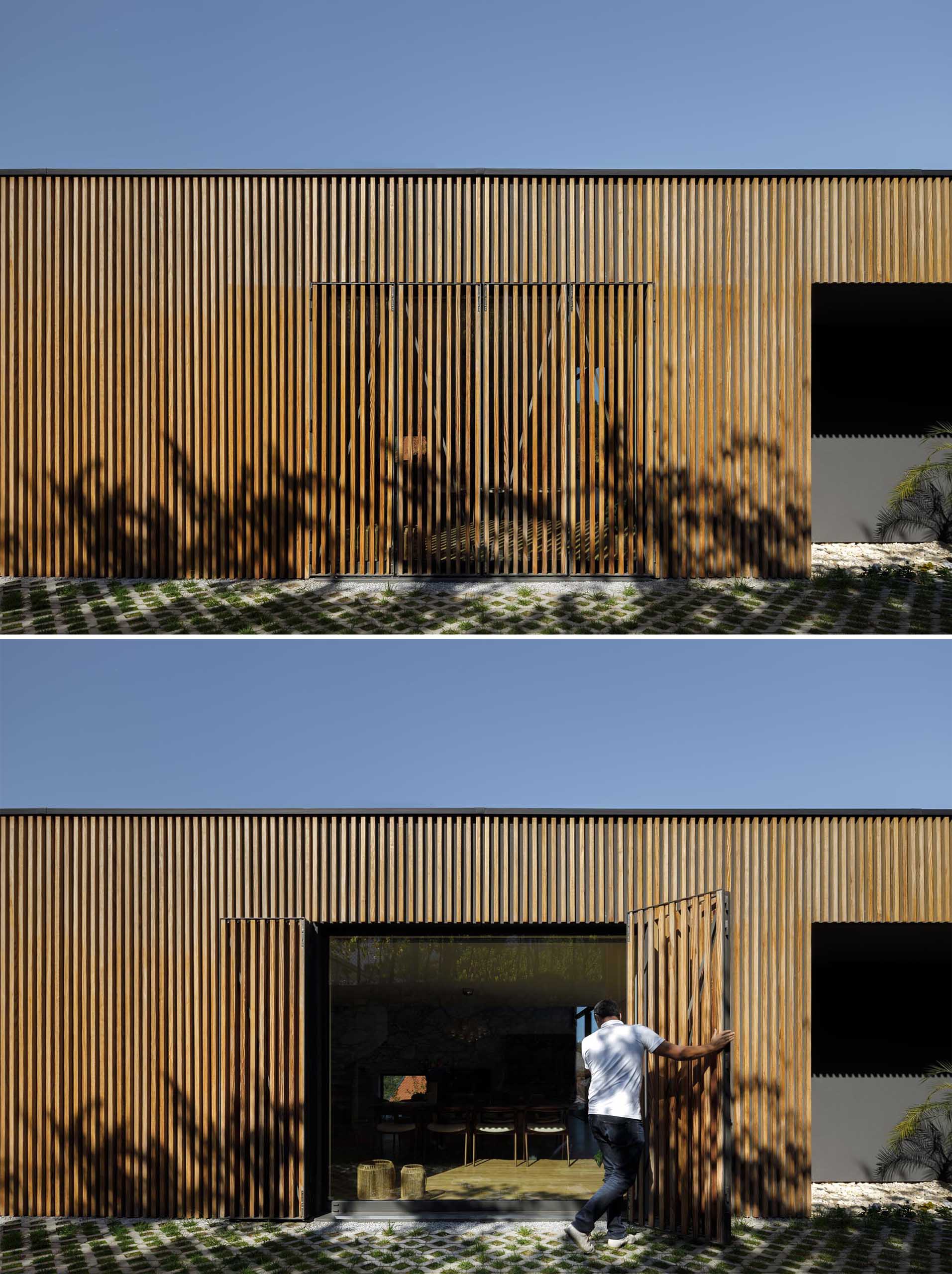 Современный дом с большим окном и деревянной решетчатой ​​стеной.