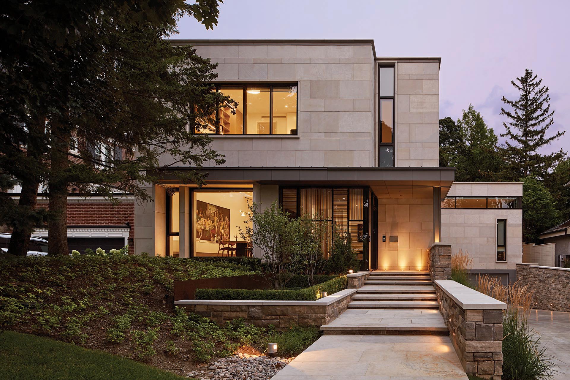 Известняк Индианы и расколотый камень Алгонкин Онтарио облицованы фасадом этого современного дома.