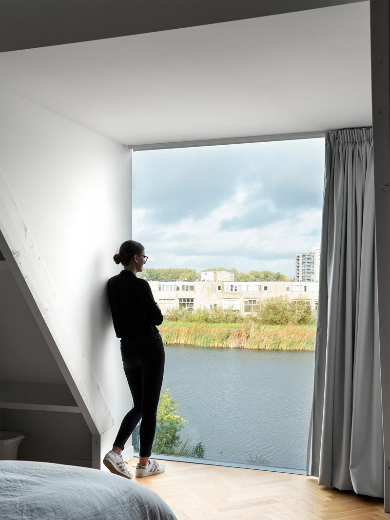 В этой современной спальне есть большое панорамное окно с видом на воду и город. # Окна # СовременнаяСпальня