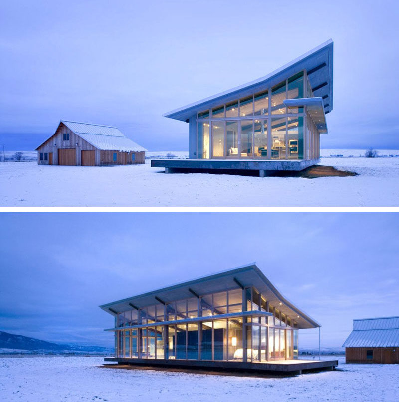 16 примеров современных домов с наклонной крышей | Покатая крыша этого современного стеклянного фермерского дома имитирует вид половины сарая за ним.