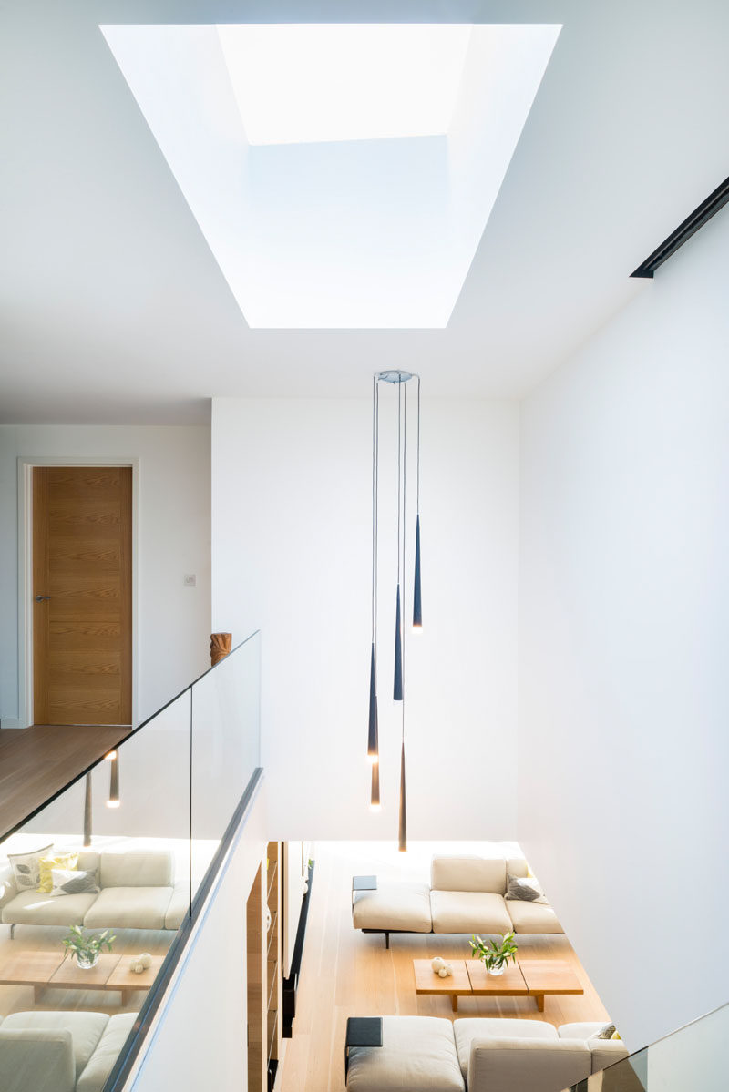 Наверху этой современная лестница находится световой люк, который заполняет пространство внизу естественным светом 