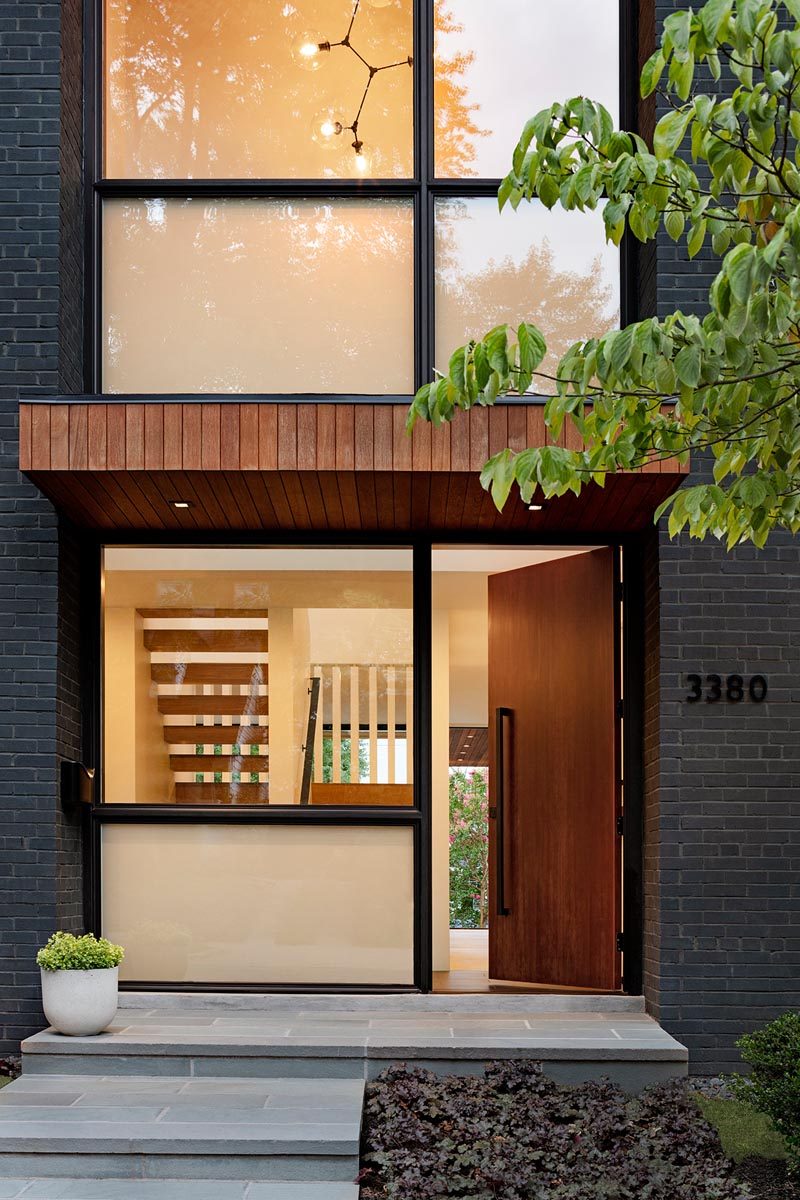 Деревянная входная дверь приветствует посетителей этого современного дома и ведет в небольшое светлое фойе. #ModernFrontDoor # Windows