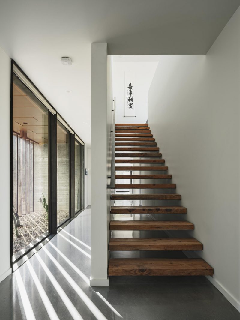 Деревянная лестница соединяет нижний уровень дома с верхним этажом.