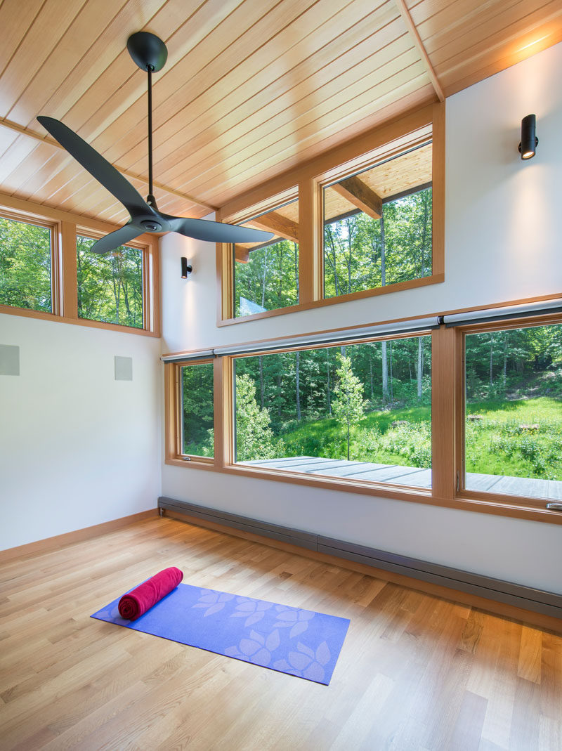 В этом современном доме, окруженном лесом, есть студия йоги с высокими потолками и видом на деревья.