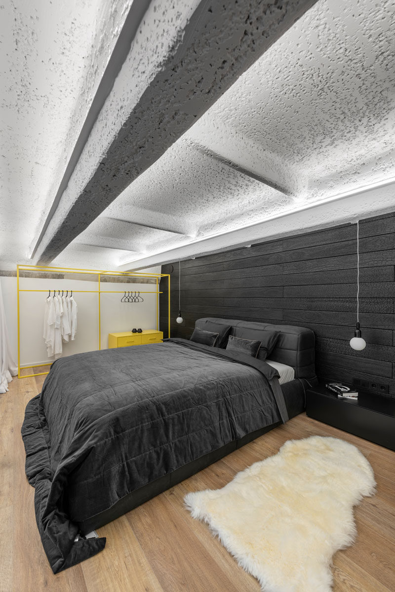 В этой современной спальне в стиле лофт мягкие белые шторы можно закрыть для уединения, а контрастная акцентная стена за кроватью покрыта обожженным деревом аккойя. Также был добавлен желтый цвет в виде отдельно стоящего открытого шкафа. #ModernBedroom #BlackAccentwall #BurntWoodWall